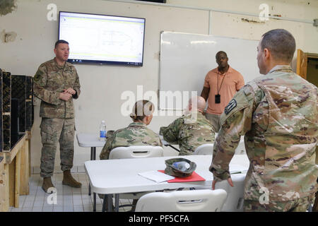 Stati Uniti Army Chief Warrant Officer 3 Ozan Lane, sinistra, un ingegnere di rete con il primo spazio brigata, risponde a una domanda dalla 1Lt. Andrew Galazzo, destra, aiutante di campo di Brig. Gen. Nikki Griffin oliva, per quanto riguarda la logistica della rete di Al Asad Air Base, Iraq, 15 agosto 2018. (U.S. Esercito nazionale Guard foto da 1Lt. Leland bianco) (Questa foto è stata modificata per motivi di sicurezza da una sfocatura fuori i badge di sicurezza). Foto Stock