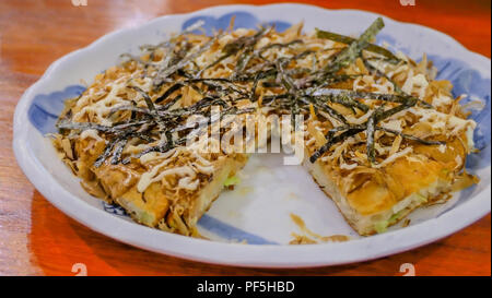 Frutti di mare Okonomiyaki pizza , Giapponese di stile frittelle sul piatto , il fuoco selettivo Foto Stock