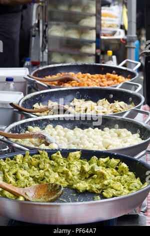 Piatti di pasta la cottura su un mercato in stallo. Foto Stock