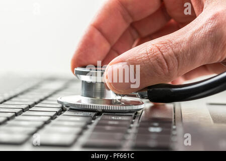 Immagine concettuale della mano di un uomo di controllare lo stato di salute del suo computer portatile utilizzando uno stetoscopio come egli verifica la presenza di malware e virus o qualsiasi elezione Foto Stock