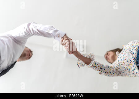 Vista dal basso di una stretta di mano di un imprenditore e la donna concettuale di un accordo commerciale o di partenariato con copia spazio. Foto Stock