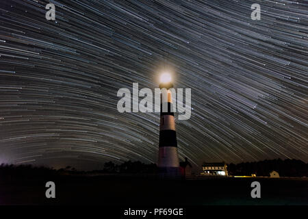 Stelle streak dal Bodie Island Lighthouse in Cape Hatteras National Seashore nella Outer Banks del North Carolina in questa lunga esposizione cielo notturno Foto Stock