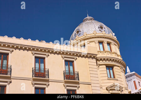 Guardando il tradizionale architettura decorativa di righe di appartamenti a Granada Spagna su una vivace giornata soleggiata con un cielo blu Foto Stock