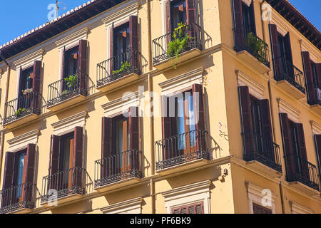 Guardando il tradizionale architettura decorativa di righe di appartamenti a Granada Spagna su una vivace giornata soleggiata con un cielo blu Foto Stock