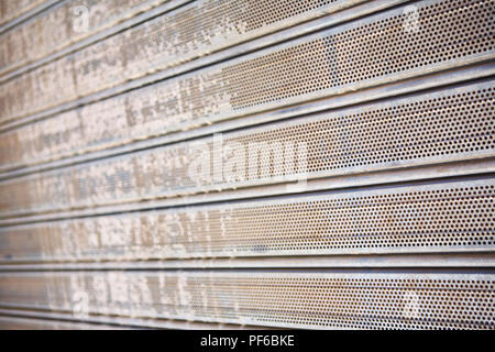 Grungy rusty logoro shop sicurezza tapparella con una maglia di fori Foto Stock