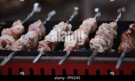 Barbecue la cottura della carne a carbone vicino a Foto Stock