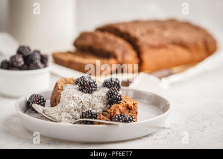 Il cioccolato vegan pane alla banana con chia pudding e more, sfondo bianco. Pulire il concetto di mangiare. Foto Stock