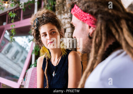 Dai capelli scuri che indossa la donna bella ciondolo guardando il suo uomo Foto Stock