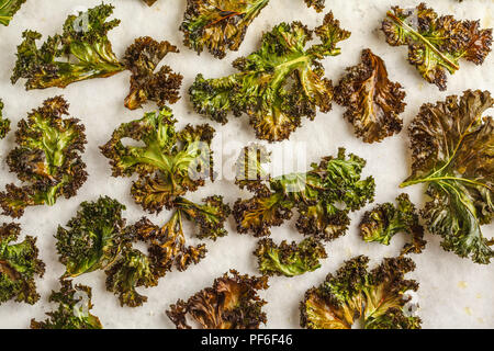 Kale chip su sfondo bianco. Pulire il concetto di mangiare. Foto Stock