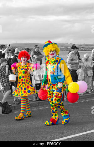 Clown colorati che partecipano alla sfilata annuale di carnevale a Weymouth, Dorset UK nel mese di agosto - colorazione selettiva dei colori, popping dei colori Foto Stock