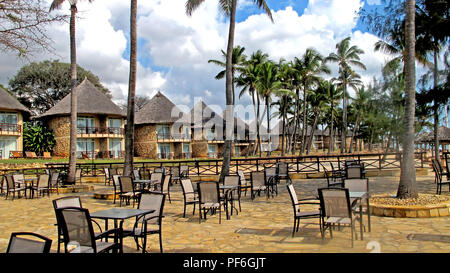 Bungalow dal tetto di paglia sulla spiaggia del Crown Plaza Hotel a Dar es Salaam, Tanzania Africa Foto Stock