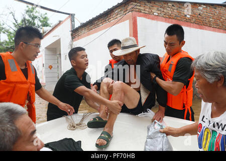 Huaibei, cinese della provincia di Anhui. 19 Ago, 2018. Soccorritori trasferire l'alluvione di filamento di persone nella città di Huaibei, est cinese della provincia di Anhui, 19 Agosto, 2018. Typhoon Rumbia ha portato pioggia per Huaibei e alcuni luoghi in Huaibei sono stati sommersi dalle inondazioni. Credito: Shanchao Wan/Xinhua/Alamy Live News Foto Stock