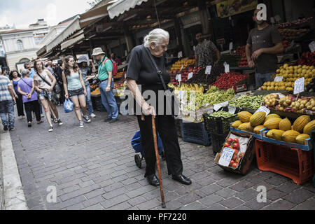 Atene, Grecia. 20 agosto 2018. Una donna anziana passeggiate passato le bancarelle del mercato. Per il momento, l'ultimo programma di aiuti per Atene termina questo lunedì. Dal 2010, i partner UE e il Fondo monetario internazionale aveva salvato più indebitati euro paese dal fallimento di ridurre il prezzo dei prestiti. In ritorno, Atene dovuto spingere attraverso riforme difficili, tagli sociali e aumenti fiscali e di impegnarsi per il loro mantenimento. Credit: Socrates Baltagiannis/dpa/Alamy Live News Foto Stock