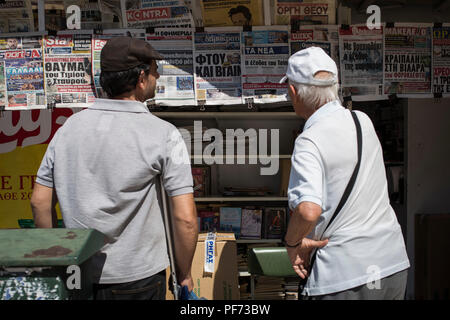 Atene, Grecia. 20 agosto 2018. Due uomini leggendo i giornali in edicola. L'ultimo programma di aiuti per la Grecia termina il 20 agosto. Dal 2010, i partner UE e il Fondo monetario internazionale aveva salvato più indebitati euro paese dal fallimento di ridurre il prezzo dei prestiti. Credit: Socrates Baltagiannis/dpa/Alamy Live News Foto Stock