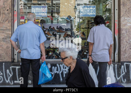 Atene, Grecia. 20 agosto 2018. Due uomini guardare la vetrina di un negozio di scarpe. L'ultimo programma di aiuti per la Grecia termina il 20 agosto. Dal 2010, i partner UE e il Fondo monetario internazionale aveva salvato più indebitati euro paese dal fallimento di ridurre il prezzo dei prestiti. Credit: Socrates Baltagiannis/dpa/Alamy Live News Foto Stock