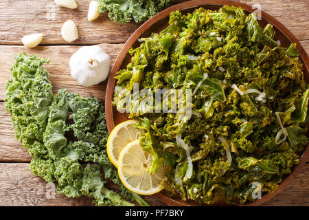 Cibo vegetariano: fritto di cavolo verza con cipolle e aglio close-up su una piastra. Parte superiore orizzontale vista da sopra Foto Stock