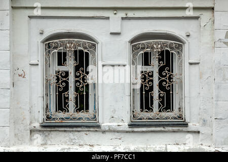 Close-up di un due vecchie finestre nella vecchia casa di un palazzo di vecchi mattoni bianchi Foto Stock