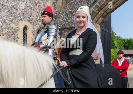 La gente a cavallo a una giostra caso vestito nel tradizionale abbigliamento medievale in Arundel, West Sussex, in Inghilterra, Regno Unito. Periodo medievale costumi. Foto Stock