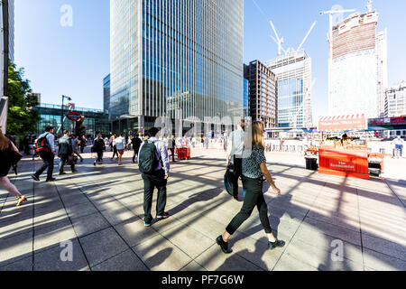 London, Regno Unito - 26 Giugno 2018: folla di persone pendolari al di fuori della metropolitana entrata della metropolitana durante la mattina i pendolari a Canary Wharf con moderni architec Foto Stock