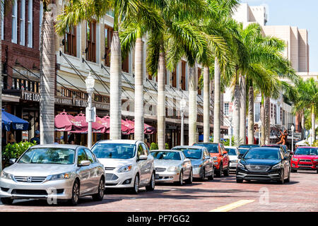 Fort Myers, Stati Uniti d'America - 29 Aprile 2018: City town village marciapiede con fila di paesaggistici palme sulla strada durante la giornata di sole in Florida golfo del Messico co Foto Stock