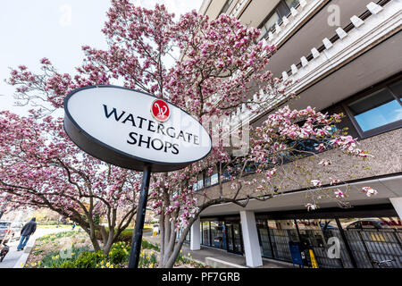 Washington DC, Stati Uniti d'America - Aprile 5, 2018: Negozi Watergate hotel edificio segno nella città capitale, edilizia residenziale closeup con rosa magnolia blossom flowe Foto Stock