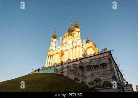 Kiev, Ucraina - 10 agosto 2018: Sant'Andrea Chiesa facciata esterna durante il tramonto dorato con luce solare costruzione restauro impalcatura, cupola dome Foto Stock