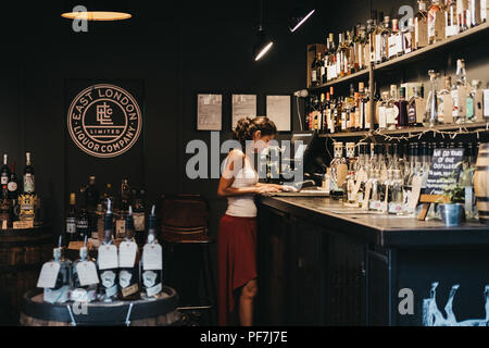 London, Regno Unito - 24 Luglio 2018: Venditore disponendo la documentazione a est di Londra Liquor azienda stand al Mercato di Borough, uno dei più grandi e più antiche cibo mar Foto Stock