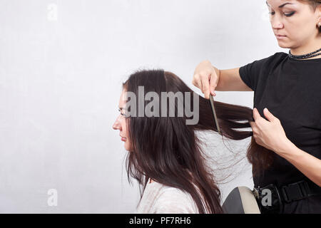 Parrucchiere femminile fa un taglio di capelli per una donna closeup nel salone di bellezza Foto Stock