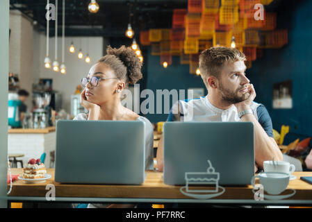 Coppia di giovani freelance sensazione di stanchezza durante il lavoro Foto Stock