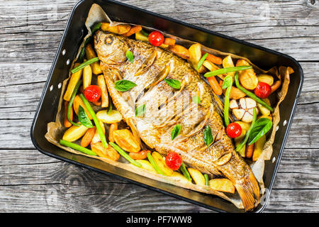 Pesce intero cotto al forno in una teglia, vista dall'alto Foto Stock