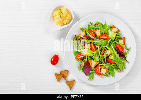 Pomodori ciliegini, crostini, capelin roe, misti foglie di lattuga, vista dall'alto Foto Stock