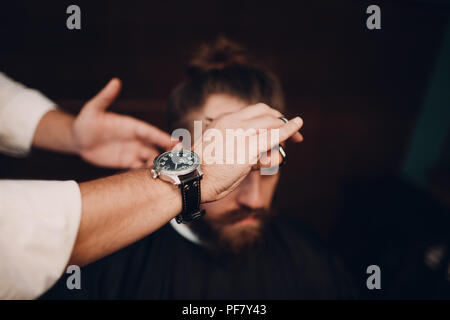 Barbiere con interni in legno. Modello barbuto uomo e barbiere. Foto Stock