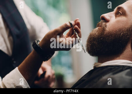 Barberia concetto. Barba modello uomo e barbiere con le forbici. Foto Stock