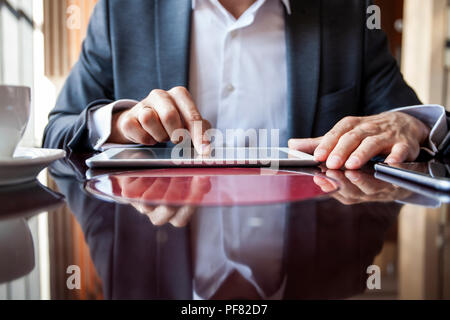 Imprenditore azienda digitale compressa, mani uomo multitasking utilizzando tablet Foto Stock