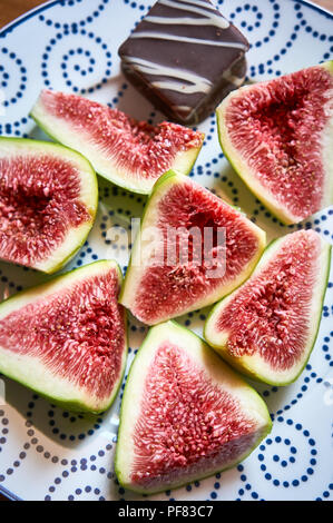 Sweet Fichi maturi. Le figure frutto su una piastra close up/macro. Mediterraneo Sano frutta fig. Vista dall'alto. Il fuoco selettivo sulla sommità figure fetta nel recipiente Foto Stock