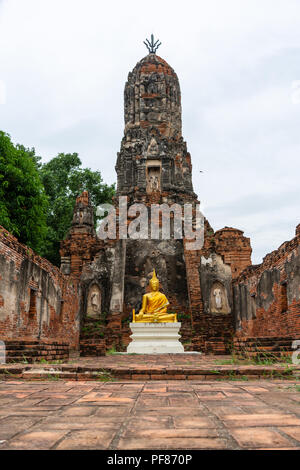 Beautiful golden immagine del Buddha in parte anteriore del vecchio pagoda in antico rovinato tempio buddista in Ayutthya, Thailandia Foto Stock