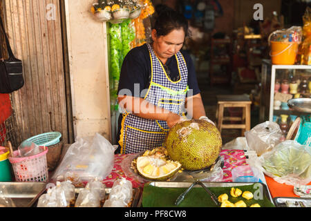 FoodTravel e turismo enogastronomico: persone vela jackfruit tropicali Frutta nel mercato locale in Thailandia Foto Stock