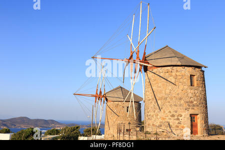 Mulini a vento di sole al tramonto sull'isola di Patmos. Dodecaneso arcipelago del mar Egeo, Grecia Foto Stock