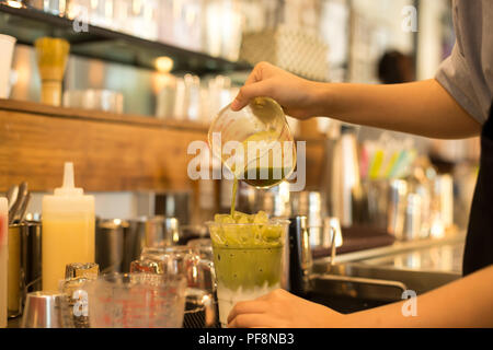 Barista rendendo iced tè verde Matcha latte Foto Stock