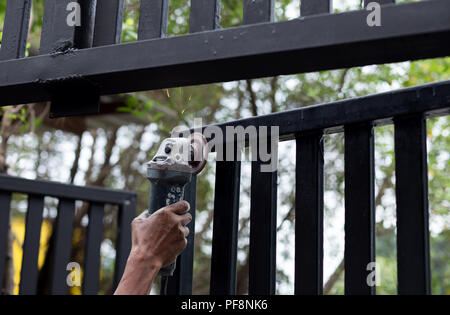 Mano azienda acciaio mola di taglio lavorando sulla porta di metallo Foto Stock