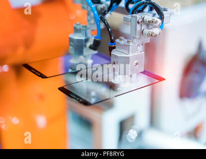 Schermata di robotica la pellicola di protezione o di copertura in vetro nella fabbricazione di fabbrica del telefono Foto Stock