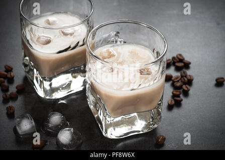 Liquore al caffè in bicchieri di ghiaccio e i chicchi di caffè nero. Foto Stock
