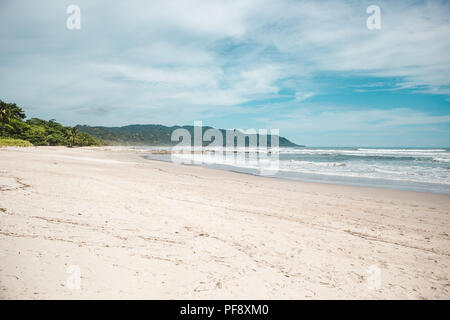 Pulire la spiaggia di sabbia di Playa Carmen, Santa Teresa, Puntaarenas provincia in Costa Rica in una calda giornata estiva con il blu del cielo Foto Stock