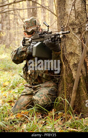 Ottobre 2009. Regione di Mosca, Russia - un soffice come l'aria giocatore indossa tedesco flecktarn camouflage mira a un nemico con m249 machin Pistola replica durante un gam Foto Stock