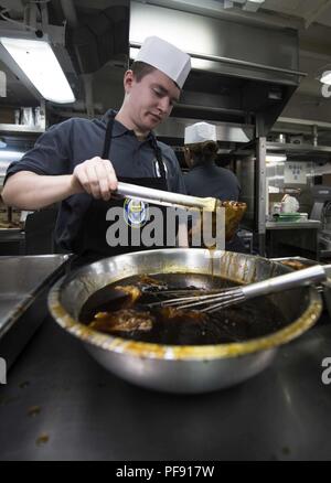 OCEAN (1 giugno 2018) specialista culinaria marinaio Dakotah Brawley, dalla primavera calda, arca. assegnato a Whidbey Island-class dock landing ship USS Rushmore (LSD 47), prepara piatti Cantonesi nervature per il pranzo durante un composito unità di addestramento esercizio (COMPTUEX). COMPTUEX è la pre-finale esercizio di distribuzione che certifica il combinato Essex anfibio gruppo pronto e il XIII Marine Expeditionary Unit la capacità di condurre operazioni militari in mare e proiettare potenza a terra durante la loro prossima distribuzione nell estate del 2018. Foto Stock