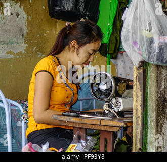 Yangon, Myanmar - Febbraio 1, 2017. Una donna di lavoro su misura alla vecchia casa di Yangon, Myanmar. Foto Stock