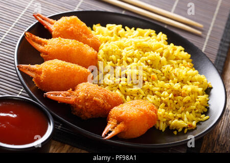 Deliziosa chele di granchio in profondo fritto con una decorazione di riso giallo e salsa di pomodoro close-up su una piastra sul tavolo orizzontale. Foto Stock