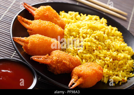 Pesce fritto chele di granchio in panatura con riso giallo e salsa di pomodoro close-up su una piastra su un piano orizzontale. Foto Stock