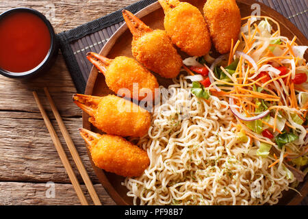 Friggere chele di granchio, udon noodles e fresca insalata di verdure close-up su una piastra sul tavolo. parte superiore orizzontale vista da sopra Foto Stock