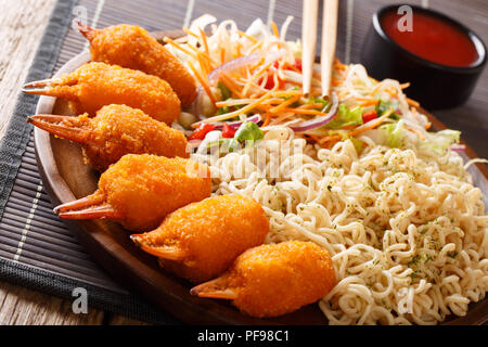 Delizioso fast food chele di granchio in panatura con egg noodles e fresca insalata di verdure close-up su una piastra su un piano orizzontale. Foto Stock